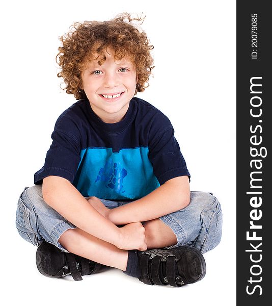 Cheerful kid relaxing on floor isoalted agianst on white.