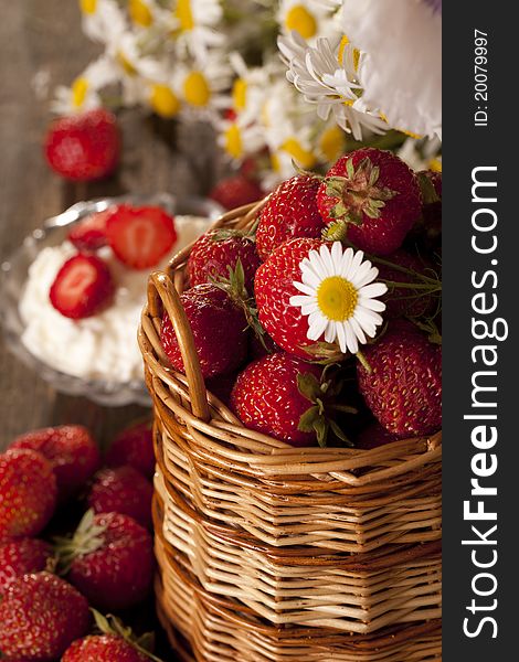 Strawberries in a basket and cheese, are a number of chamomile flowers, environmentally friendly product