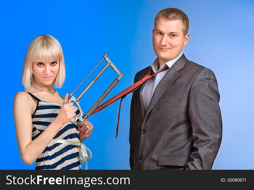 Beautiful young couple fool around with a saw. Beautiful young couple fool around with a saw