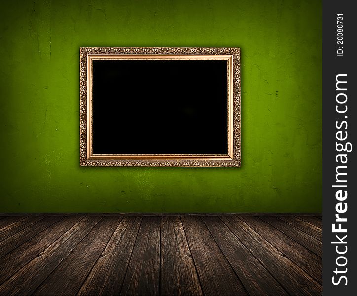 Dark vintage green room with wooden floor and golden frame hanging on the wall. Dark vintage green room with wooden floor and golden frame hanging on the wall