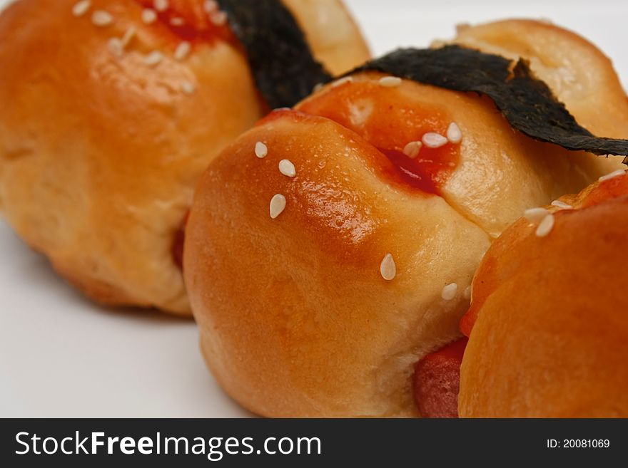 A small sausage bread with sauce and seaweed