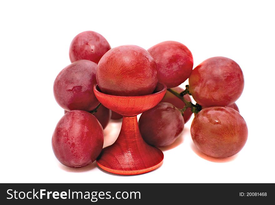 The branch of red grapes lies on a table. The branch of red grapes lies on a table.