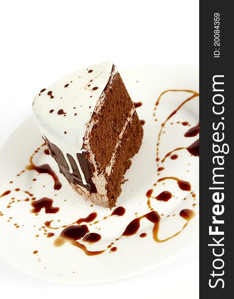 Chocolate cake on a white plate with chocolate sauce