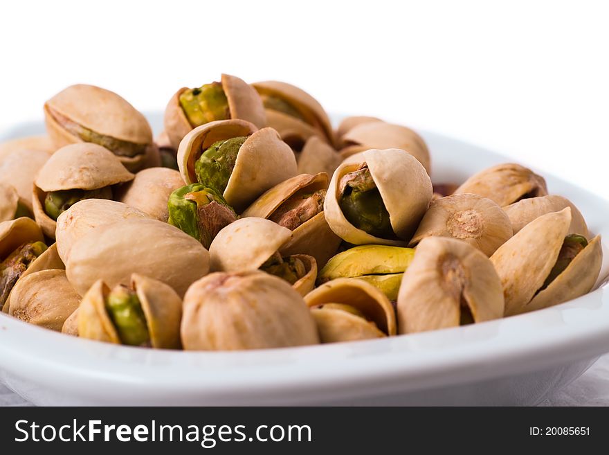 Pistachios in a bowl on the table isolated on white background