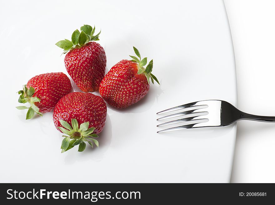 Ripe strawberries on plate with fork, on white background. Ripe strawberries on plate with fork, on white background