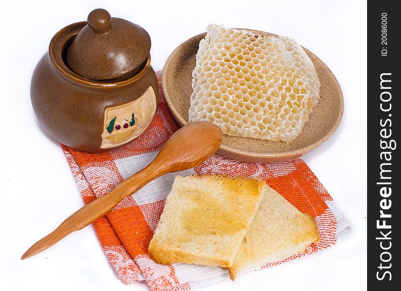 Pot of honey, toasts and honeycomb isolated on white background