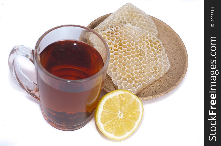 Black tea, half lemon and honeycomb isolated on white. Black tea, half lemon and honeycomb isolated on white