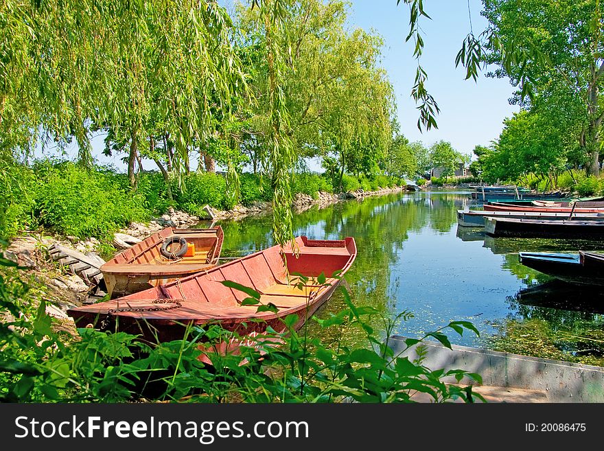 Anchored boats floating on water in small bay