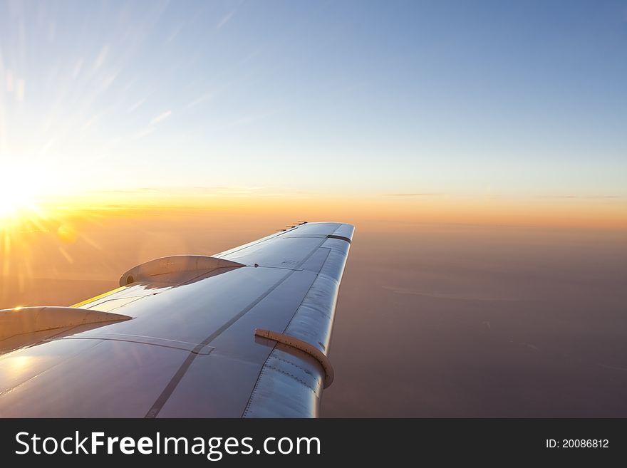 Sunset Above Wing Of An Airplane With Romantic Sky