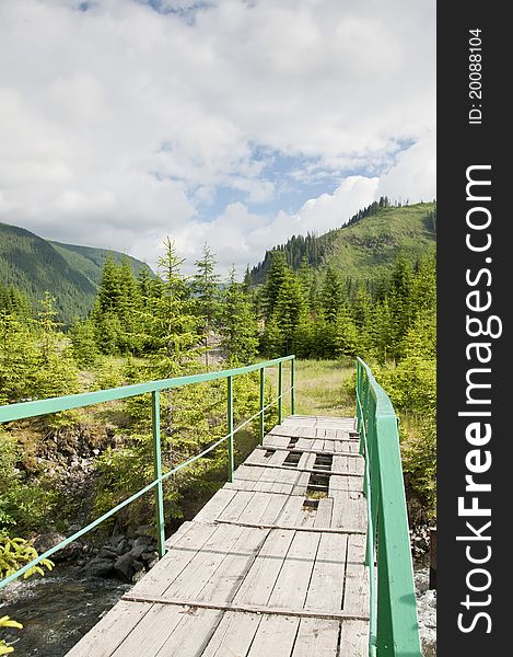 Old wooden bridge over a stream in the mountains. Old wooden bridge over a stream in the mountains