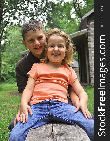 A color photograph of a brother and sister laughing. A color photograph of a brother and sister laughing