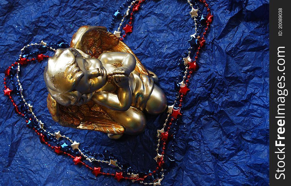 Praying angle in a middle of red white and blue necklace heart on dark blue background. Praying angle in a middle of red white and blue necklace heart on dark blue background