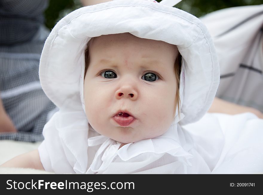 The portrait of the baby in park, on a back background is visible the father. The portrait of the baby in park, on a back background is visible the father