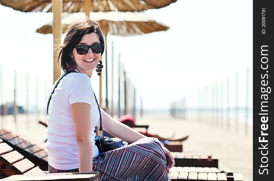 Happy young woman relax on beautiful beach at fresh summer morning and enjoy first ray of sun. Happy young woman relax on beautiful beach at fresh summer morning and enjoy first ray of sun