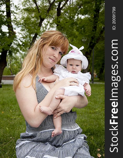 The portrait of the baby and mother on cover in the park. The portrait of the baby and mother on cover in the park