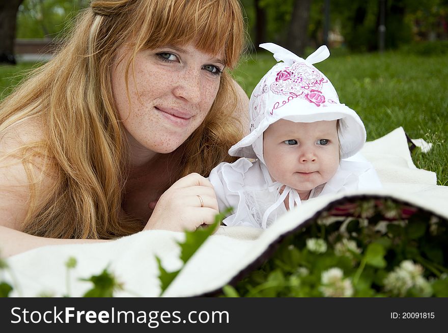 The portrait of the baby and mother on cover in the park. The portrait of the baby and mother on cover in the park