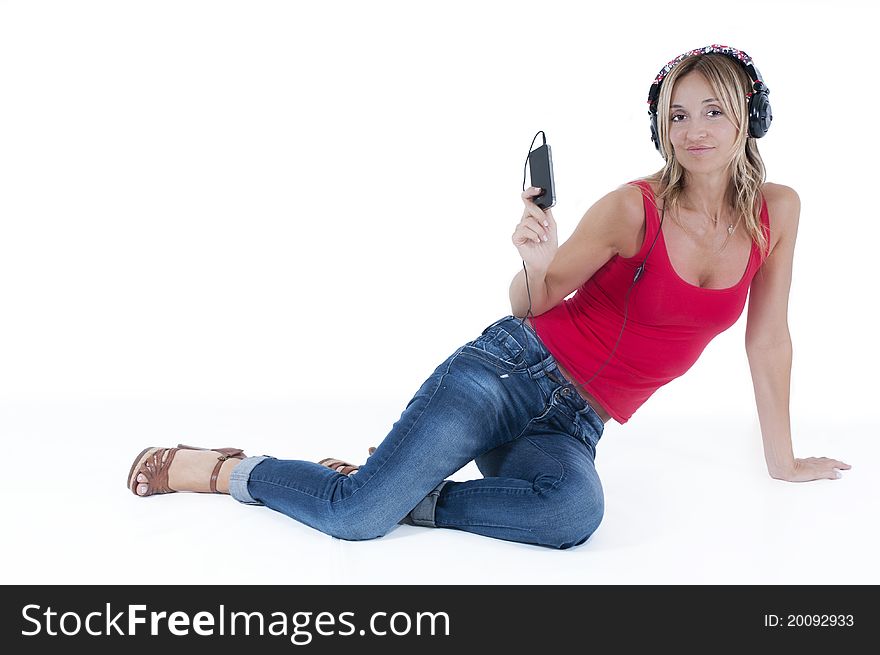 Trendy woman listening to music on her mp3 player wearing headphones. Trendy woman listening to music on her mp3 player wearing headphones