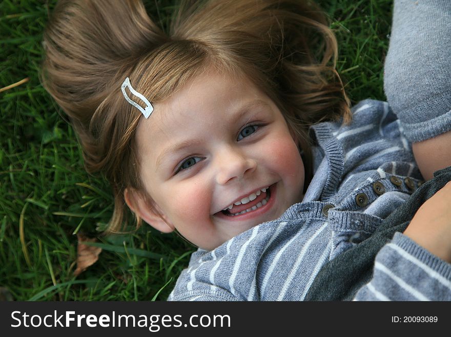 Face of young girl laying on grass. Face of young girl laying on grass