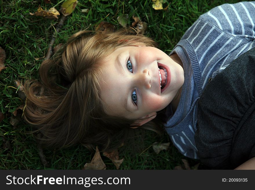 Face of young girl laying on grass. Face of young girl laying on grass
