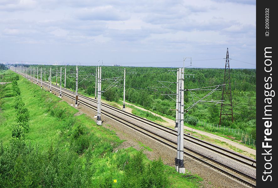 Straight stretch of railroad passing through the green countryside