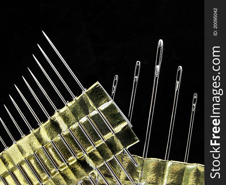 Sewing needles on black background