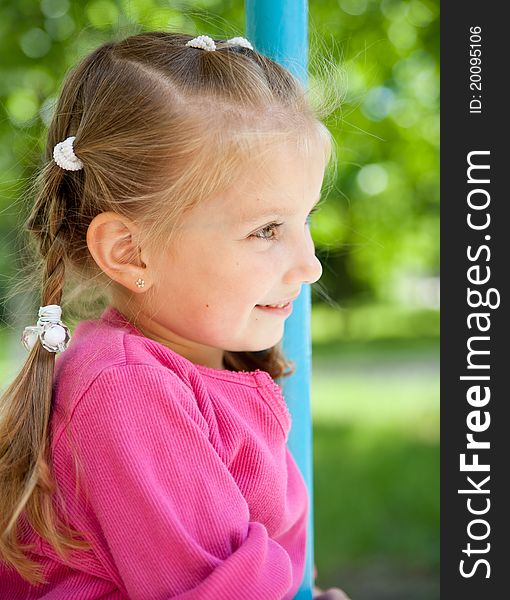 Cute little girl smiling in a park close-up