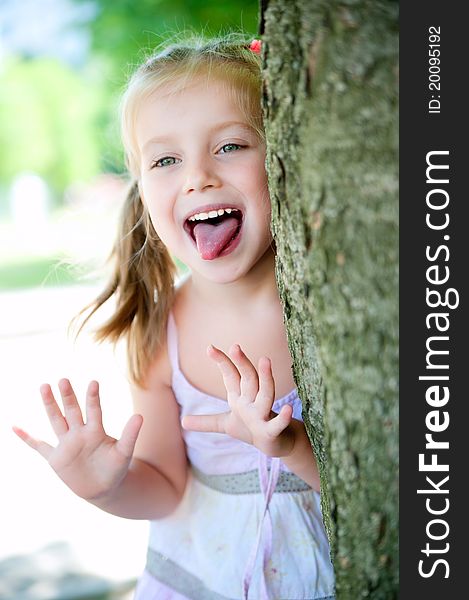 Cute little girl smiling in a park close-up