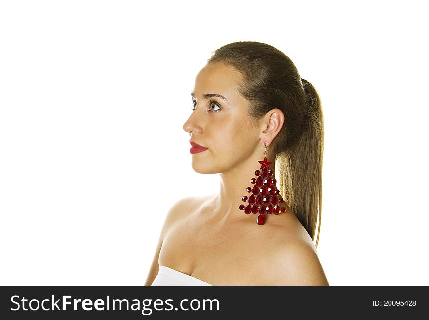 Close-up of a beautiful young woman c big earrings made ??of precious red stones in the shape of a Christmas tree. Isolation. Close-up of a beautiful young woman c big earrings made ??of precious red stones in the shape of a Christmas tree. Isolation