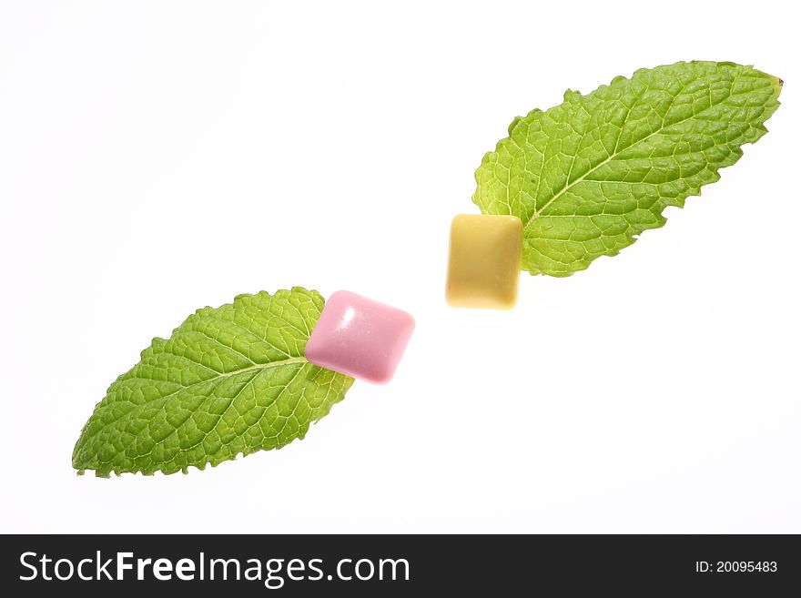 Mint leaf and chewing gum on white background