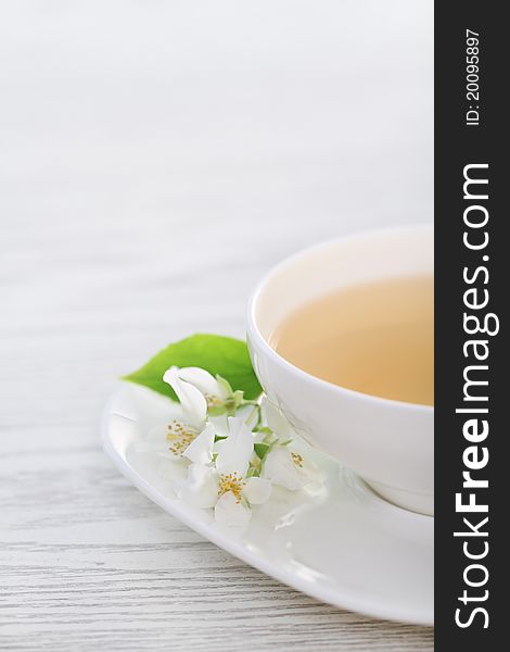 Cup of the jasmin tea on white wooden background