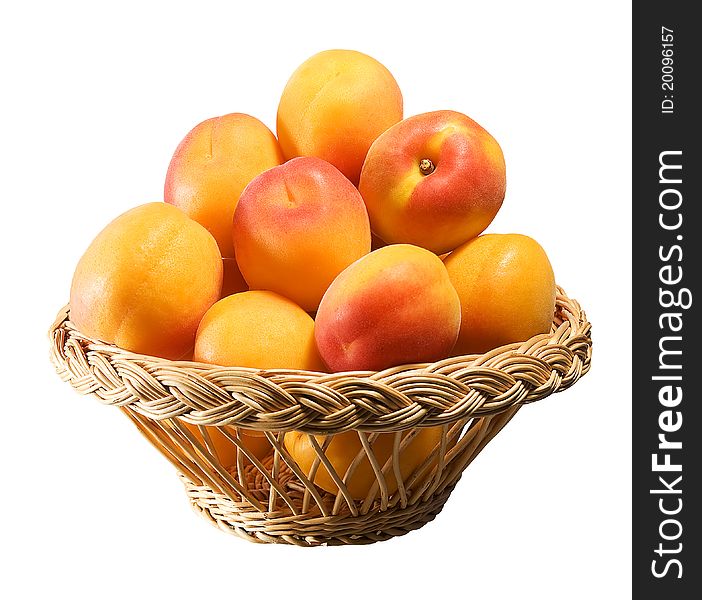 Wooden basket full of apricots isolated on white