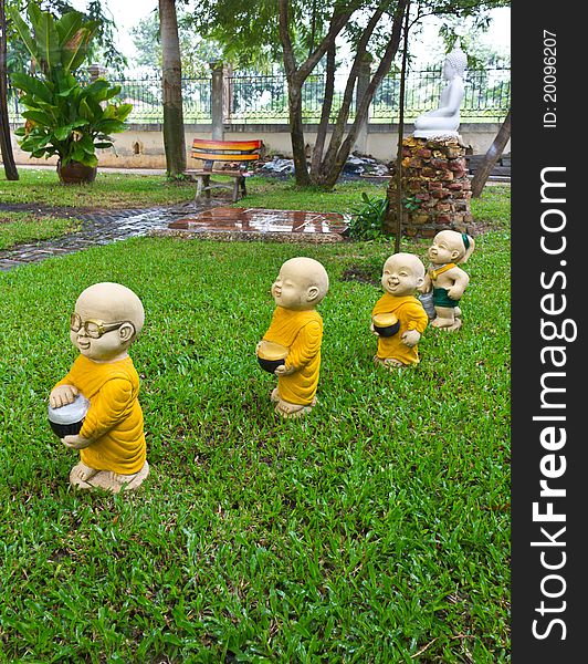 The stucco temple boy with monks was walking on the lawn. The stucco temple boy with monks was walking on the lawn.