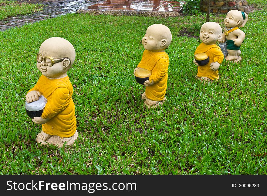 The stucco temple boy with monks was walking on the lawn. The stucco temple boy with monks was walking on the lawn.