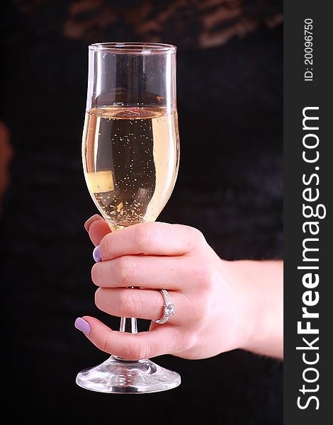 A close up of a ladies hand holding a glass of champagne. A close up of a ladies hand holding a glass of champagne
