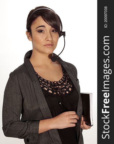 Beatiful brunette woman holding a notebook and wearing a telephone headset. Beatiful brunette woman holding a notebook and wearing a telephone headset.