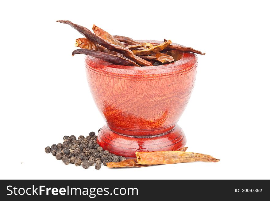 Dried chillies and peppers in wooden mortar