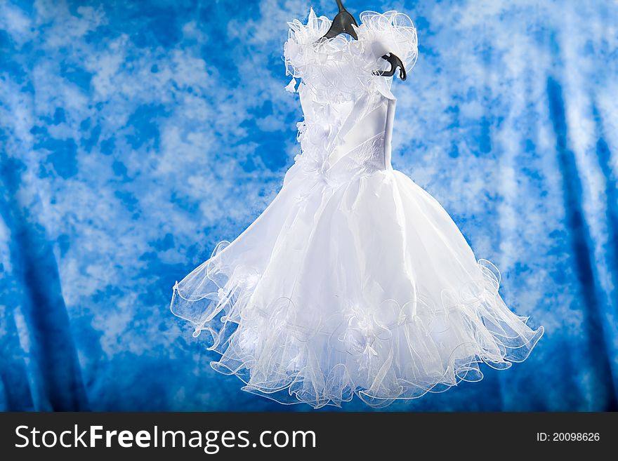 White dress elegant air to a little girl on a blue background. White dress elegant air to a little girl on a blue background