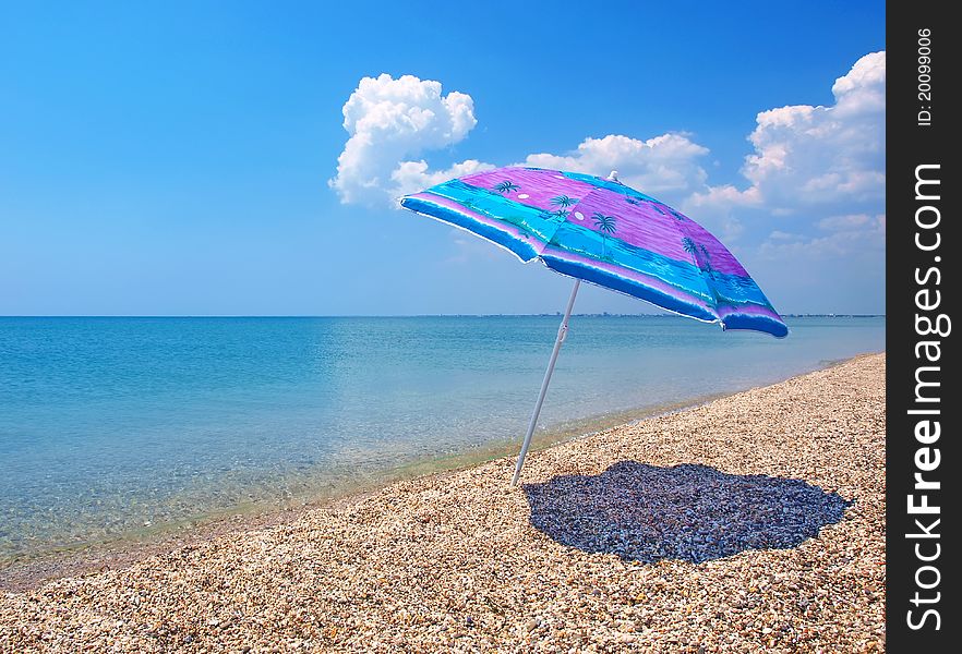 Beach umbrella, calm sea and sky with clouds on a background. Beach umbrella, calm sea and sky with clouds on a background