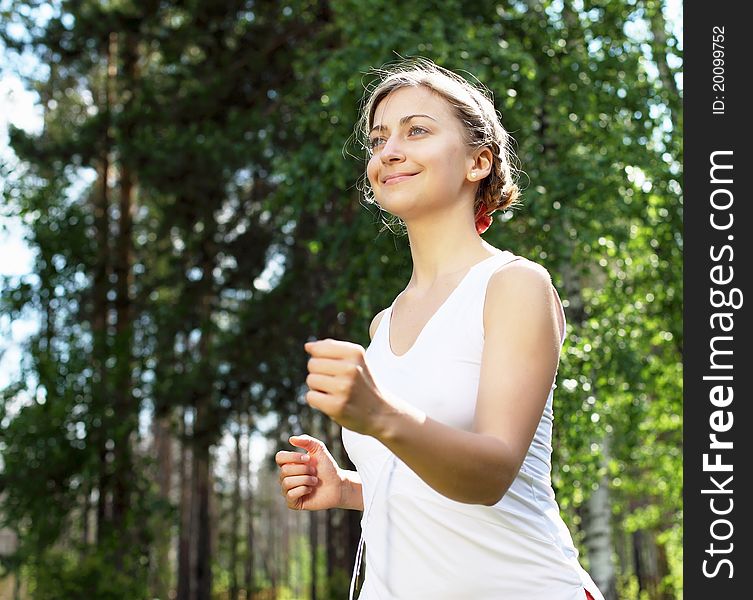 Young girl in a white shirt and red pants likes to run outdoors.