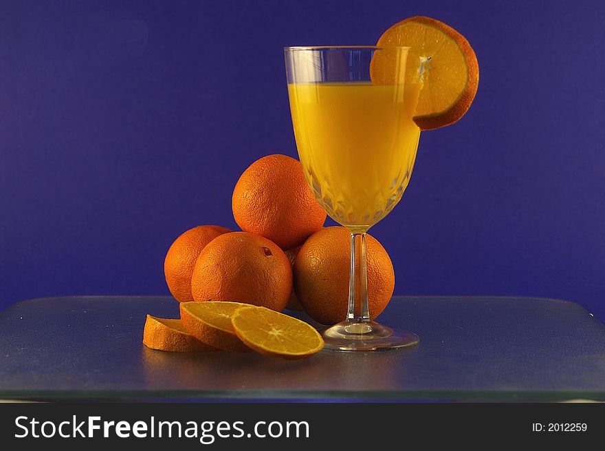 Oranges and orange juice against a blue background