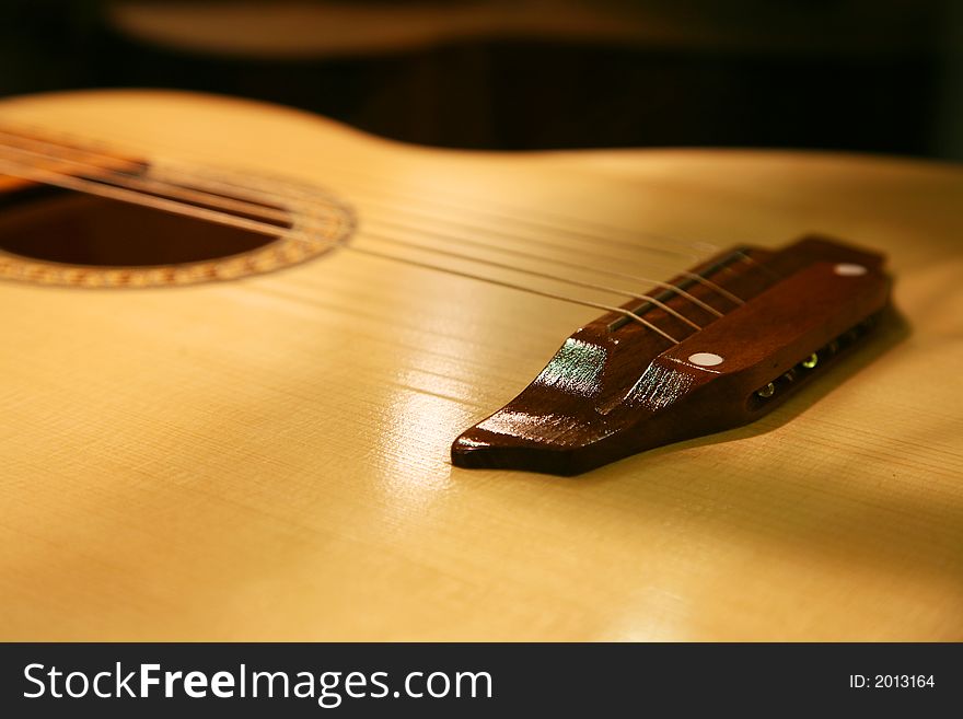 The varnished guitar lays on a black background