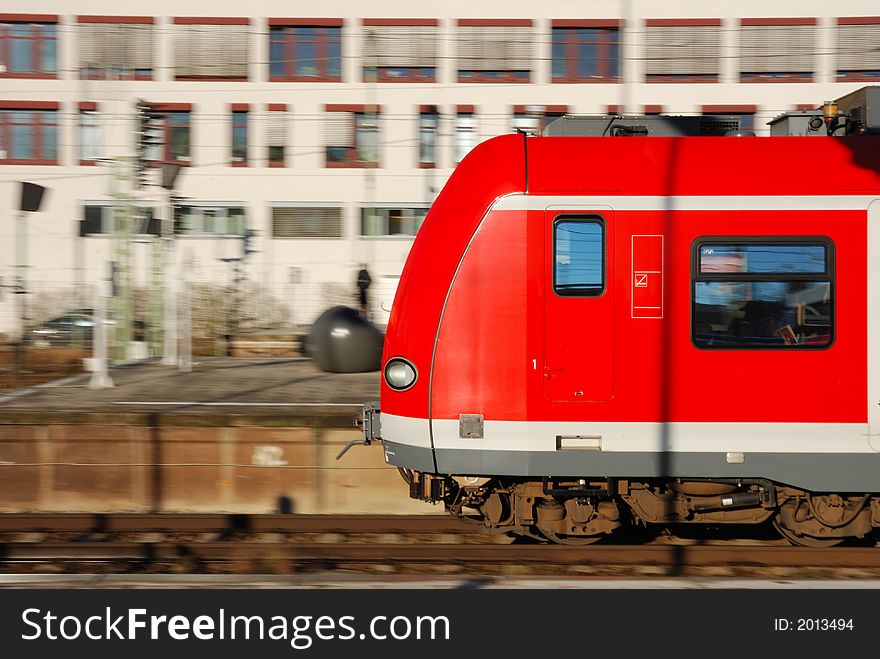 Speeding commuter train (S-Bahn) in Munich, Germany. Slight motion-blur of background.