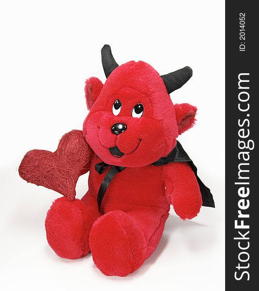 Devil toy with a red heart isolated on white background