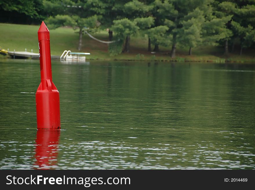 Red bouy on the lake near the shore