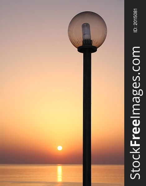 A sunset with lamppost at the ocean.