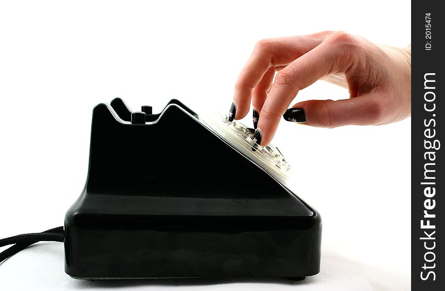 Woman's hand with black nails dialing an old black telephone