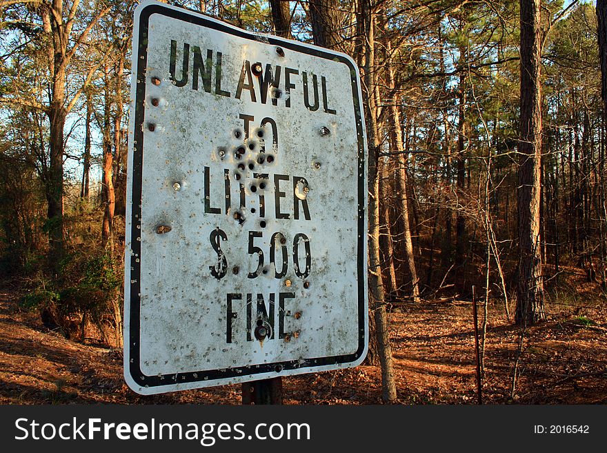 Unlawful to Litter sign riddled with bullets. Unlawful to Litter sign riddled with bullets