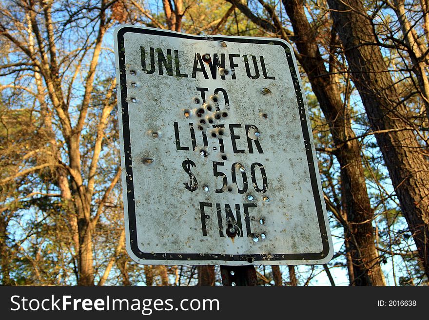 No littering sign - with tons of bullet holes