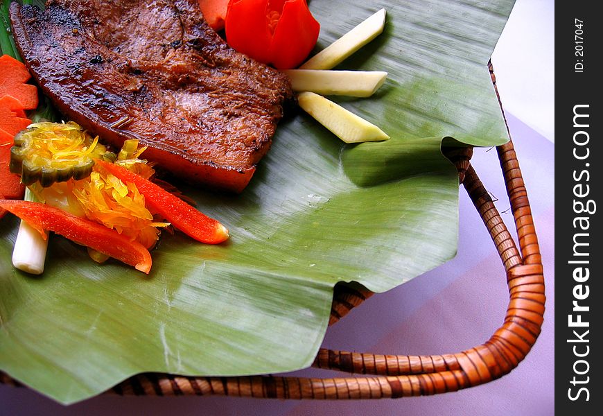 Delicious pork chop served on a banana leaf. Delicious pork chop served on a banana leaf