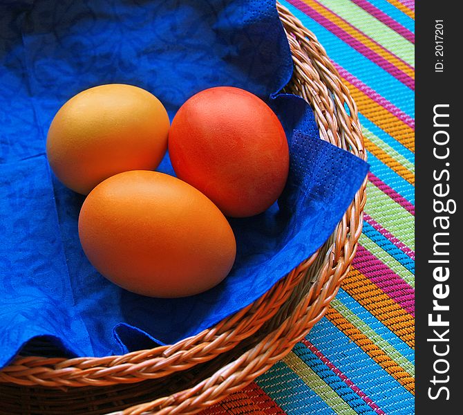 Three eggs in the baskets on striped fabric